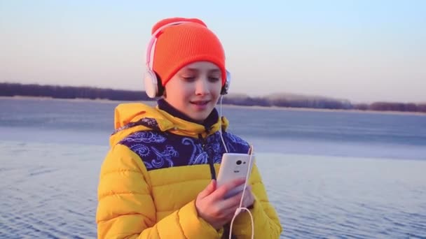 Chica joven con teléfono escuchando música en los auriculares, chica con auriculares bailando música . — Vídeos de Stock