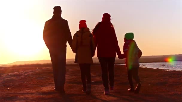 Wandelen aan de kust baai en gelukkige familie. Familie wandelen aan Zeekust. Silhouetten zonsondergang. — Stockvideo
