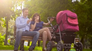 Anne ve baba dondurma yemek, yaz aylarında bebek arabası park, Aile tatil günü ile çekip