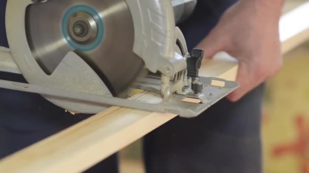 Arbeiter sägt das Brett mit der Kreissäge, repariert Haus mit der Elektrosäge, Nahaufnahme — Stockvideo