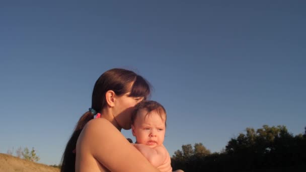 Μητέρα κρατά ένα μικρό παιδί στην αγκαλιά της και φιλιά — Αρχείο Βίντεο