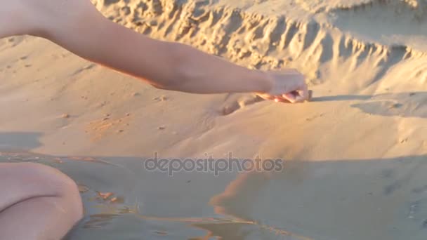 Drawing hearts on sand on river bank — Stock Video