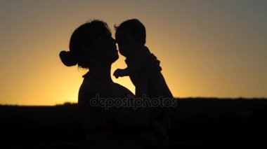 Anne bebek günbatımında oynamaya kadar atar. Ağır çekim.