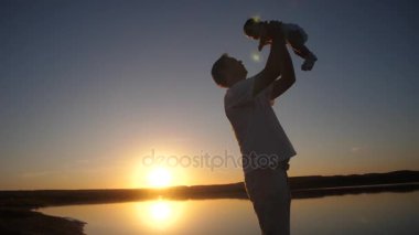Bebek babası ellerinde kırmızı akşam güneşi düşüş dönüyor. Ağır çekim.