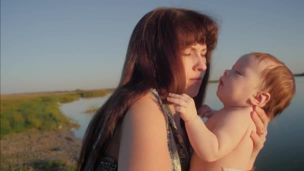 Baby is holding a young mother in her arms and smiling. Slow motion. — Stock Video