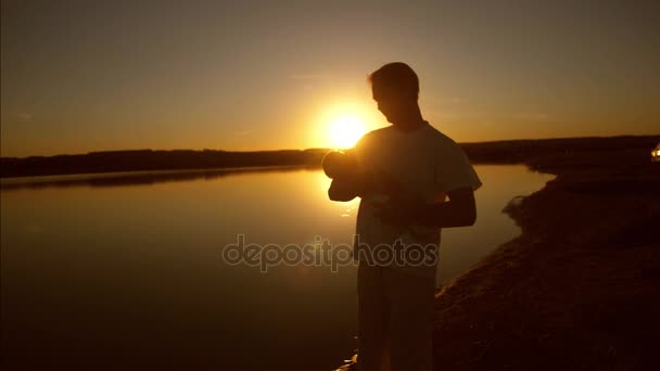 Padre dando vueltas en brazos del pequeño bebé al atardecer sol de la noche. Movimiento lento . — Vídeo de stock