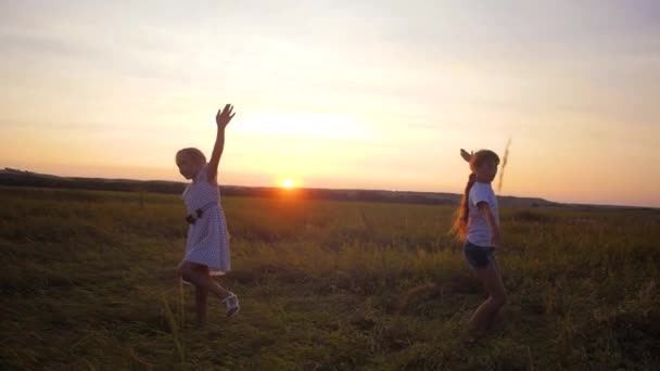 Kinder Teenager laufen abends bei Sonnenuntergang der roten Sonne über die Straße. Zeitlupe. — Stockvideo