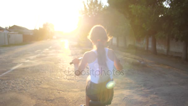 Девочка-подросток едет по улице на велосипеде. Медленное движение — стоковое видео