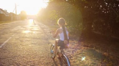 Genç kız sokakta üzerinde Bisiklete biniyor. Ağır çekim