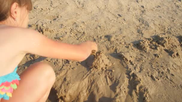 Tiener meisje maakt zandkastelen — Stockvideo