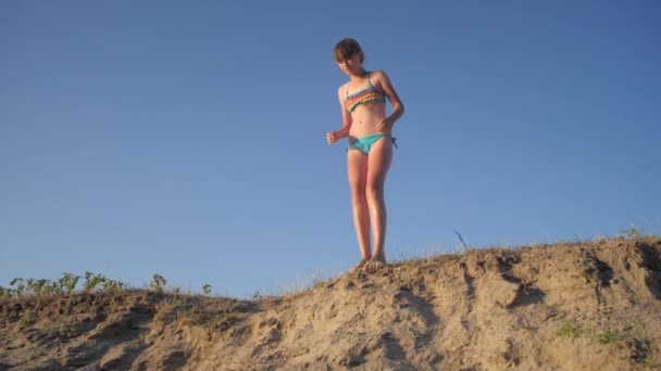 Vidám lány ugrás szikláról homok, lassított felvétel — Stock videók