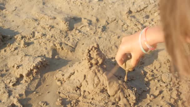 Teenager girl makes sandcastles — Stock Video