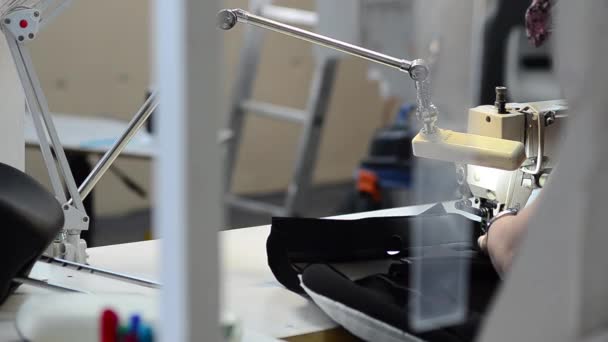 Cucitrice cuce sulla macchina da cucire, lavora nel laboratorio di cucito — Video Stock