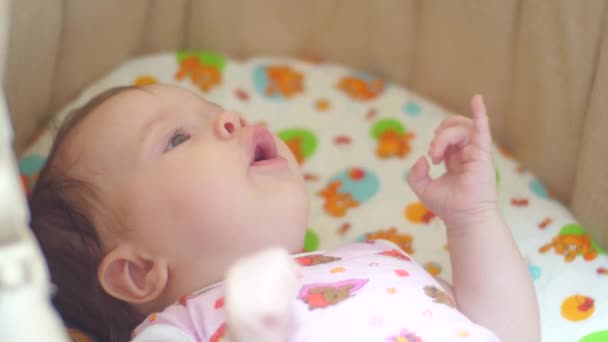 Bebis i sängen ler och talar. — Stockvideo