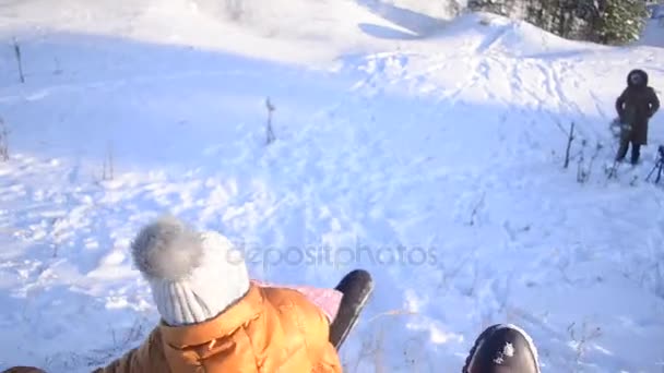 Jeune fille luge d'une colline dans le parc de neige d'hiver, tournage vidéo en mouvement . — Video