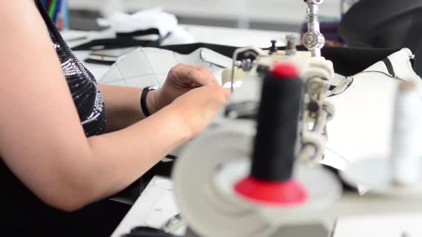 Seamstress sews product with needle and thread in sewing workshop — Stock Video
