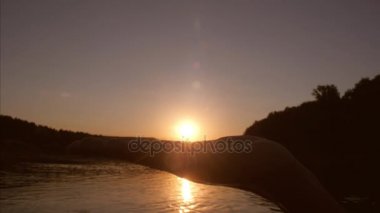 Kızlar el güneş avuç içi Günbatımında Bay üzerinde tutarak