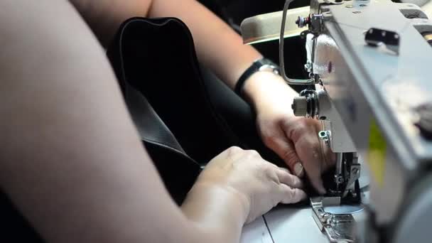 Cucitrice cuce la pelle sulla macchina da cucire, lavora nel laboratorio di cucito — Video Stock