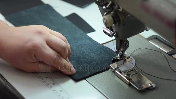 Seamstress sews leather on sewing machine, works in sewing workshop, close up — Stock Video