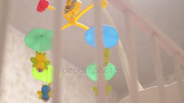 Parlak ve renkli oyuncaklar beşik iplik. Ağır çekim,