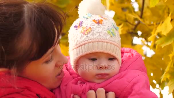 Baby is in the arms of mother in park in fall. — Stock Video