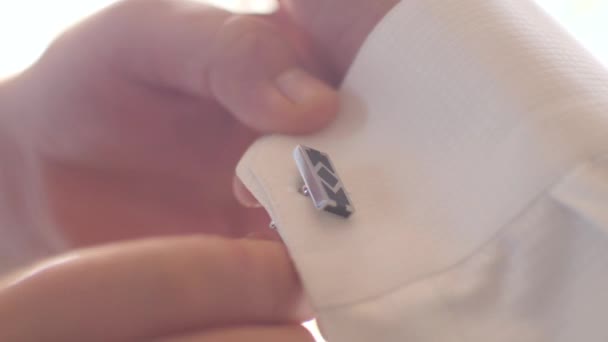 男子扣袖扣在他的衬衫袖子。男人穿着白衬衫. — 图库视频影像