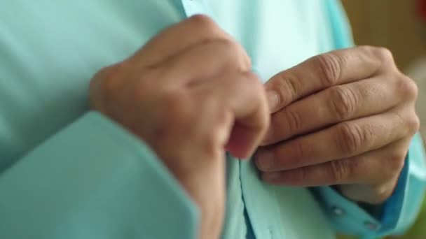 Man puts on shirt, man fasten buttons on shirt — Stock Video