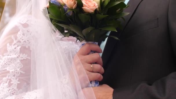 Flicka med blommor i vit klänning kramas man, bukett mångfärgade rosor i händerna på bruden — Stockvideo