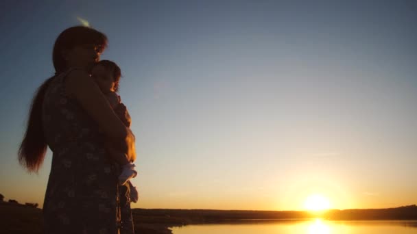 El bebé está en brazos de la madre al atardecer sol dorado. Movimiento lento . — Vídeo de stock