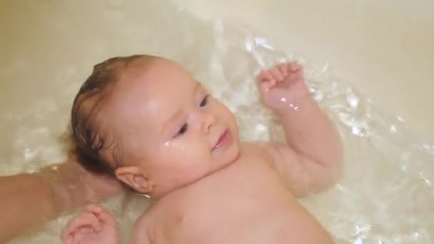 Kleine baby baadt in badkamer en lacht. — Stockvideo