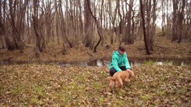 Onu köpek kızla sonbahar altın Park'ta oynamaktadır. Ağır çekim.