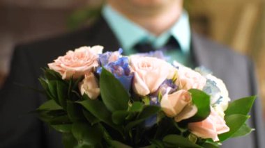 adam güzel bir buket gül elinde tutuyor.