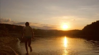 Sunset beach ayak altından su üzerinde çalışan genç kız yavaş hareket çekim