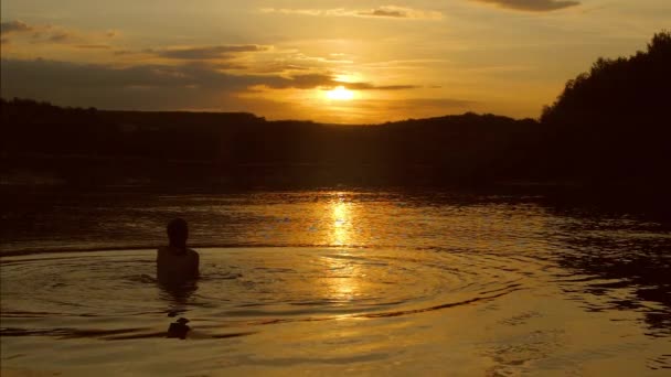 Ragazza adolescente è in acqua al tramonto . — Video Stock