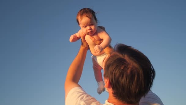 Vader gooit baby in blauwe hemel. Slow motion. — Stockvideo