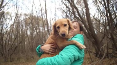 Köpek sahipleri ellerinde oturur ve onu öper. Ağır çekim.