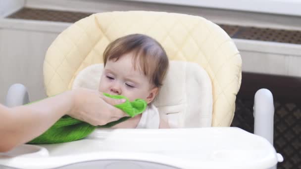 Baby ist launisch und weint auf dem Hochstuhl in der Küche. — Stockvideo