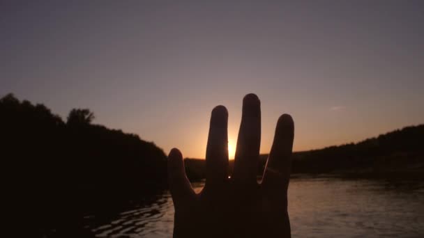 Mano de hombre en resplandor de sol poniente . — Vídeo de stock