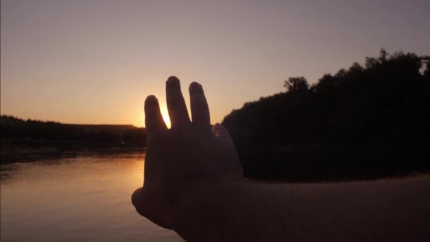 Man breidt zijn hand aan zon — Stockvideo