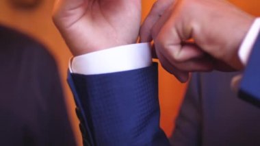 Takım elbiseli adam onun kollu beyaz gömlek ayarlar.