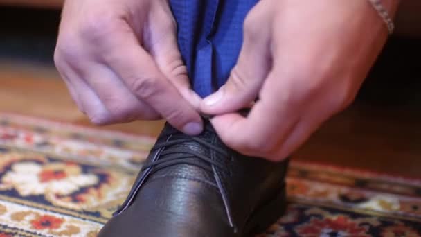 Мужчина завязывает сапоги на свои черные туфли — стоковое видео