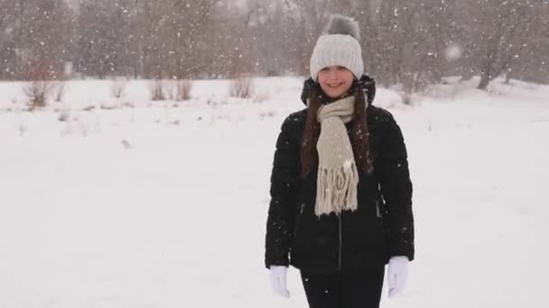 Chica en el parque está feliz de que ella está caminando sobre nieve blanca . — Vídeos de Stock