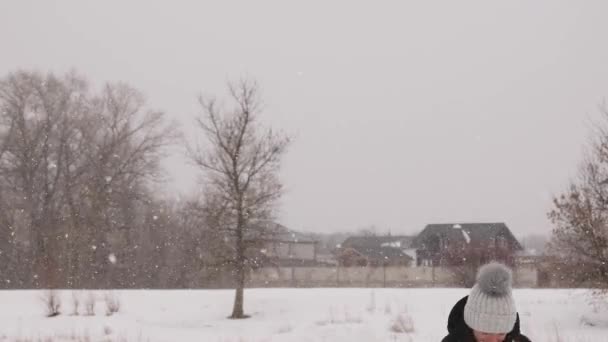 Hermosas chicas jugando bolas de nieve en el frío parque de invierno riendo y sonriendo . — Vídeos de Stock