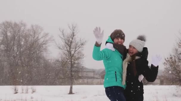 Adolescentes felizes e despreocupados estão jogando na rua forte geada e nevasca . — Vídeo de Stock