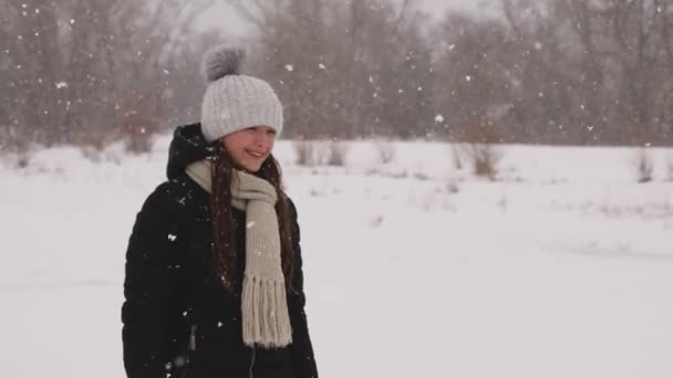 Menina bonita está andando na rua coberta de neve com forte geada e sorrindo . — Vídeo de Stock