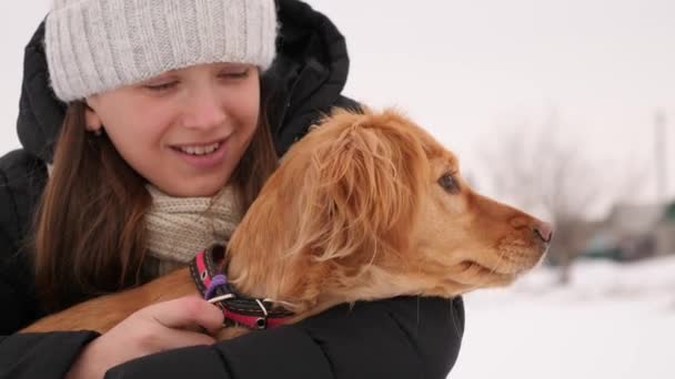 Flickan håller hund för krage som skäller på förbipasserande. — Stockvideo