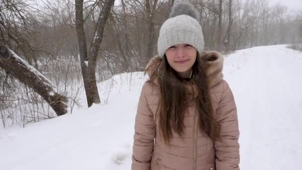 Szczęśliwa dziewczyna idzie przez miasto pokryte śniegiem i uśmiecha się. Kurzawa. Ruchu Winter.Slow.. — Wideo stockowe