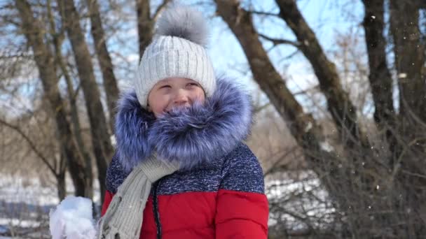 Ребенок играет в парке на снегу. Портрет маленькой девочки на улице зимой. Slow Motion . — стоковое видео