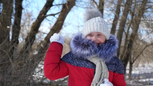 Teen dívka v parku v sněhové koule. Portrét holčičku venku v zimě. Zpomalený pohyb. — Stock video