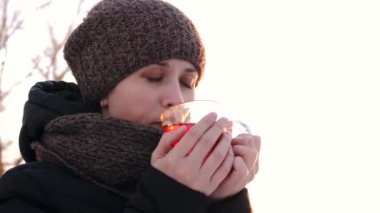 Kendini ayaz açık havada sıcak çay ile kışın ısınma ve gülümseyen genç kız.
